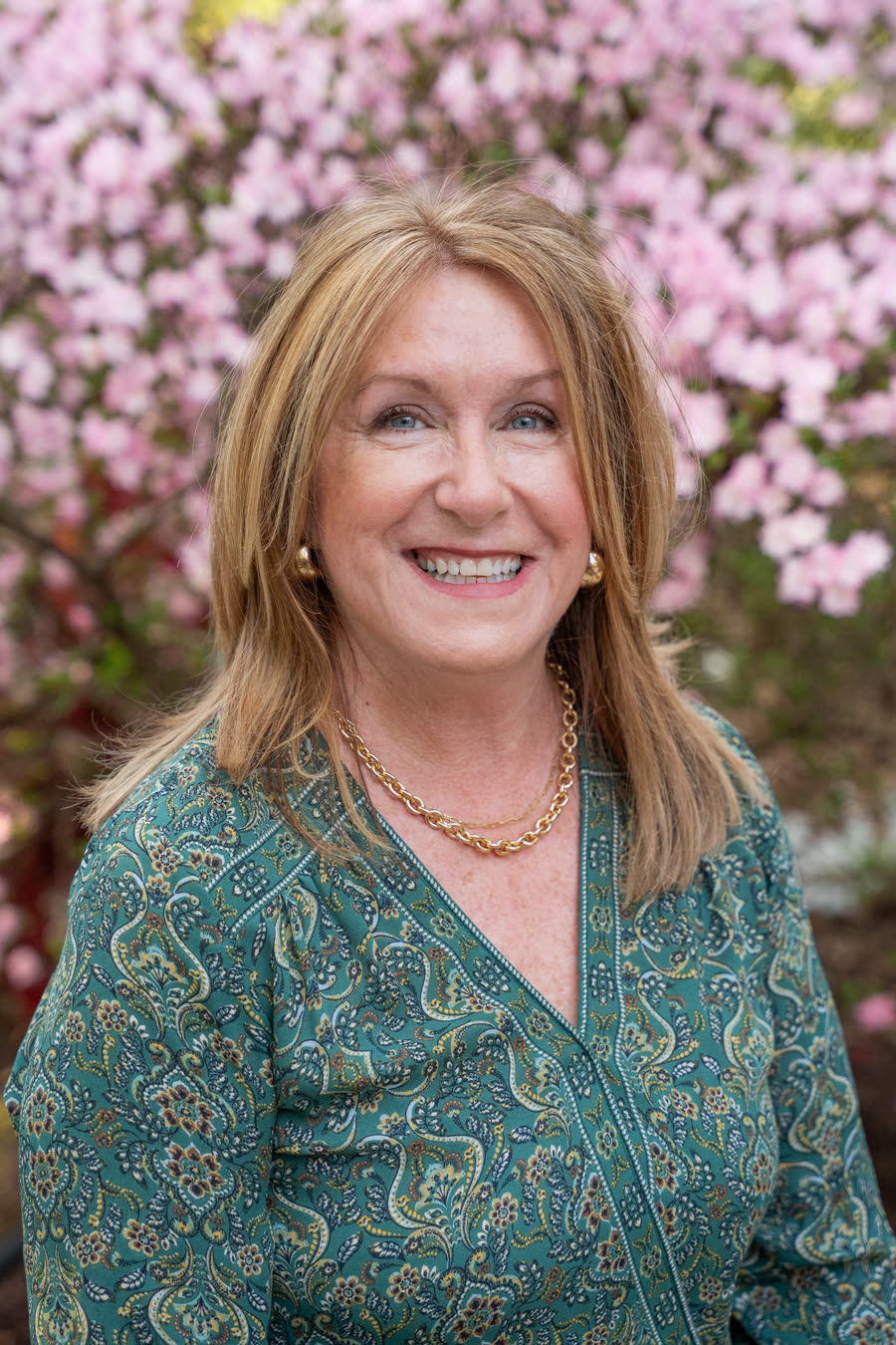 Portrait of Carolyn Lorente smiling in a garden.